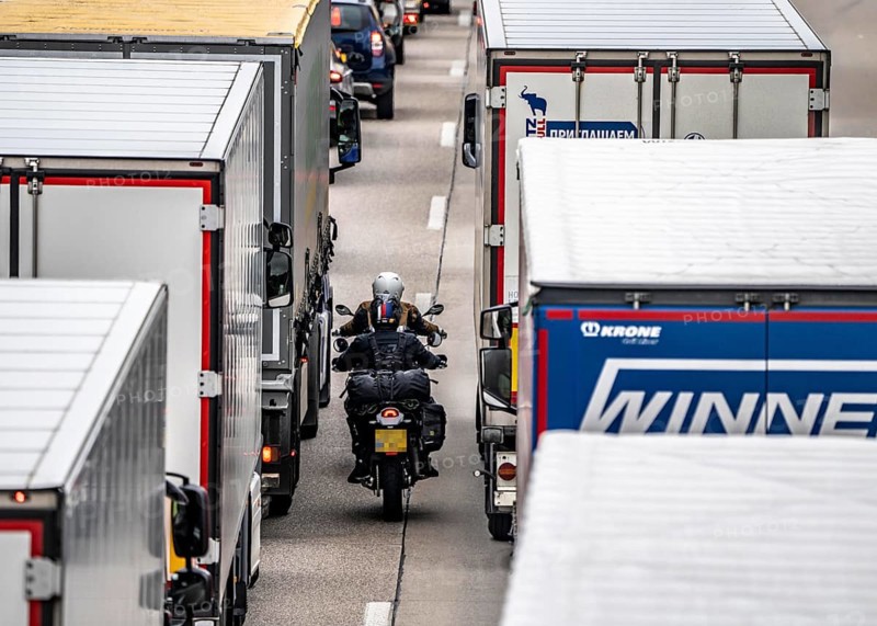 Motorcyclists squeeze past in the middle of the road between vehicles, in a 9 km long traffic jam on the A40 motorway eastbound, between the Dutch border near Venlo, in front of the Wankum junction, due to roadworks, traffic routing to one lane, many trucks in traffic jam, North Rhine-Westphalia, Germany, Europe