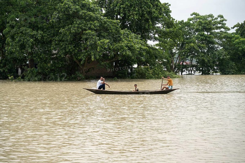 Morigaon, India. 4 July 2024. People travel in a boat to cross a flooded area, in a flood affected village in Morigaon district in India's northeastern state of Assam on July 4, 2024. Torrential rains and surging rivers across northeast India have killed at least nine people, with more than 1.5 million people affected