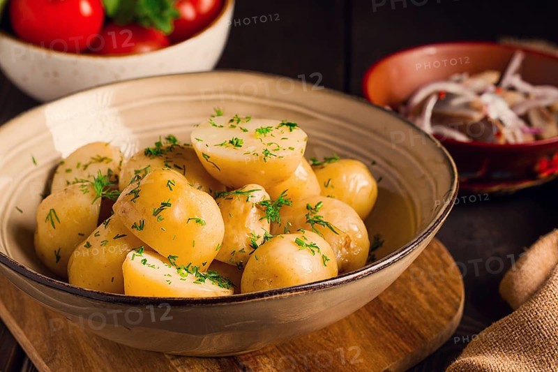 Frisch gekochte, neue Kartoffeln, mit Dill, auf einem Holztisch, selektiver Fokus. Nahaufnahme, Tonung, keine Personen