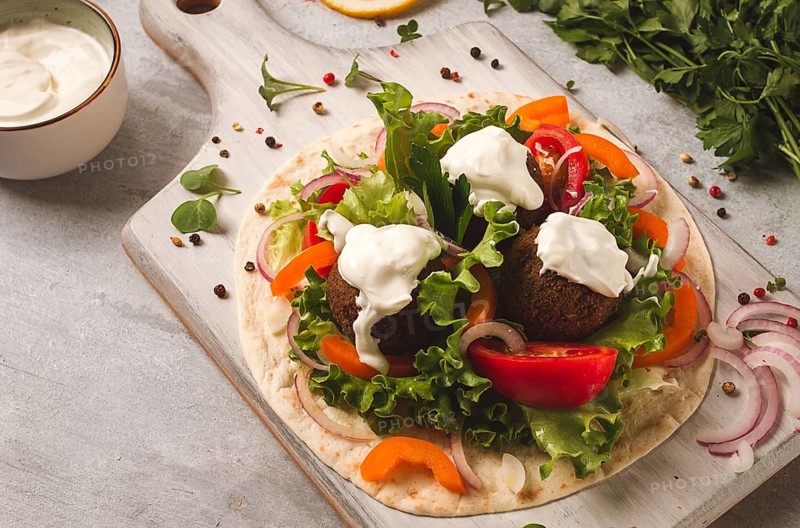 Tortilla with falafel and vegetable salad, white sauce, Arabic cuisine, top view, homemade, no people, vegetarian food