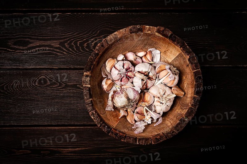 Fresh garlic, in a wooden plate, top view, close-up, no people