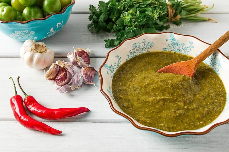 Tkemali sauce, traditional Georgian cuisine, green cherry plum, with ingredients for sauce, cilantro, mint, hot pepper, garlic, on a white wooden table, close-up, rustic, food background, no people, selective focus, sauce, green sauce, tkemali, georgian cuisine, homemade