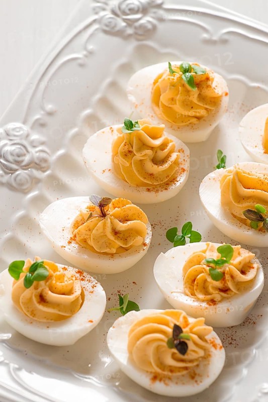 Boiled eggs stuffed with yolk with mayonnaise, on a white plate, selective focus, blurry, close-up, no people