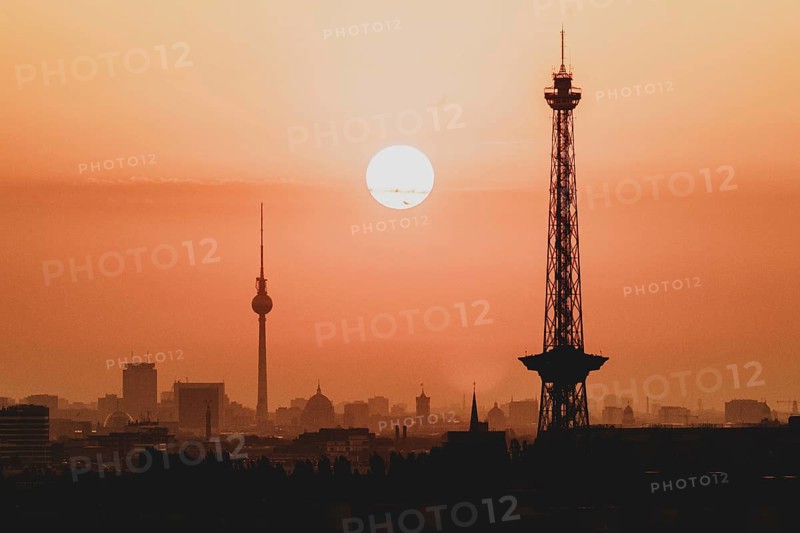 The sunrise emerges behind the city skyline with the television tower and the radio tower in Berlin, 04/09/2024