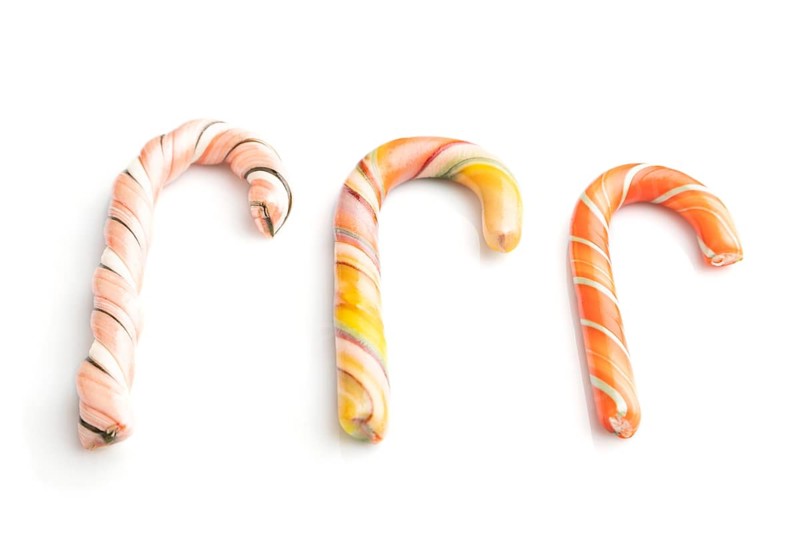 Three christmas cane candies isolated on white background. close up, side view