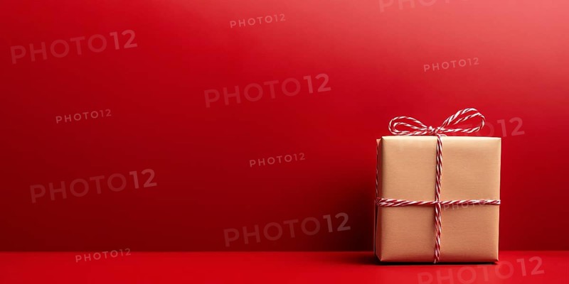 Banner with small Christmas gift box wrapped in kraft paper on red background with copy space. Generative Ai, AI generated