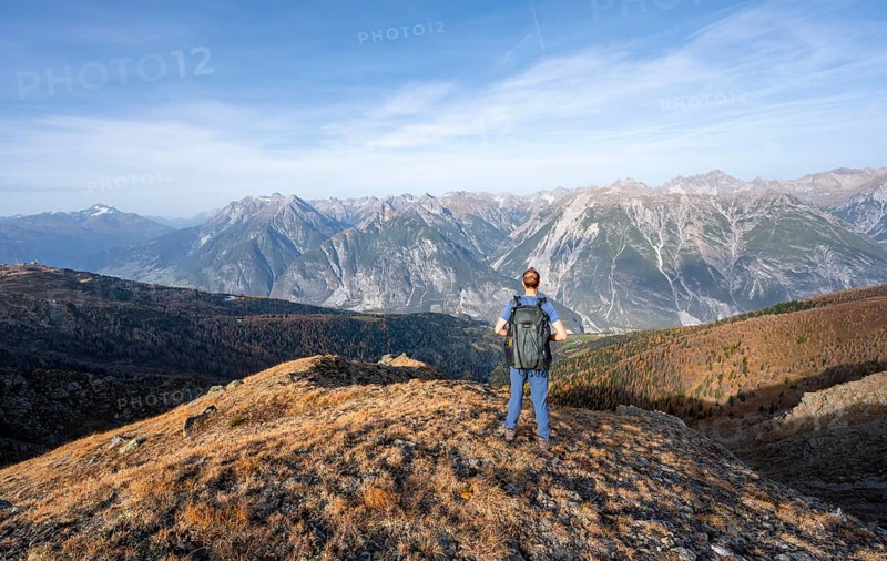 Mountaineer in front of a mountain panorama on a mountain ridge, view from the ridge of the Venet to mountains of the Parzinn group in the Lechtal Alps, in autumn, Venet crossing, Ötztal Alps, Tyrol, Austria, Europe