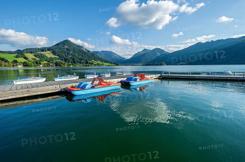 Electric boats and pedal boats at jetty, boat hire, Markt Schliersee, Schliersee, behind mountains Brecherspitz or Spitzing and Schlierseespitz, Mangfall mountains, Bavarian Prealps, Upper Bavaria, Bavaria, Germany, Europe