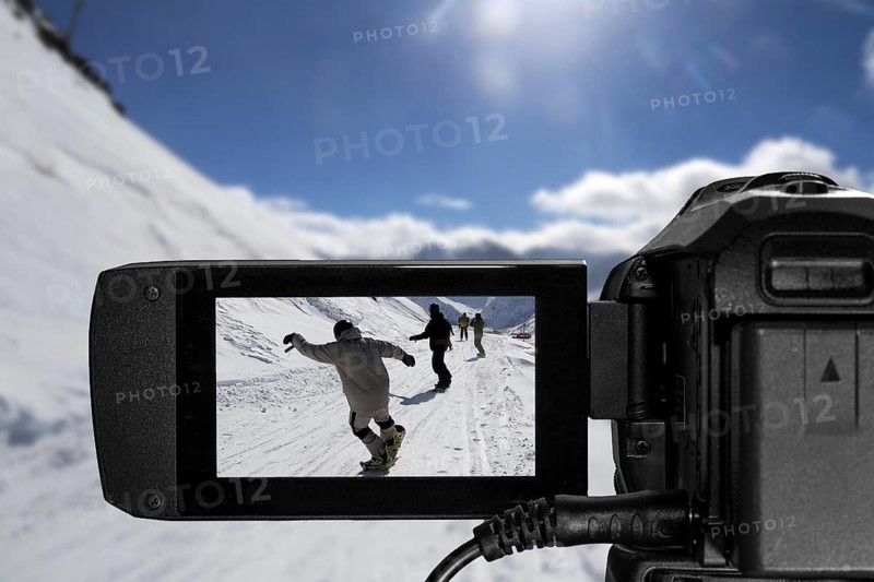 Close-up from a camcorder during video recording in a ski resort (composing)