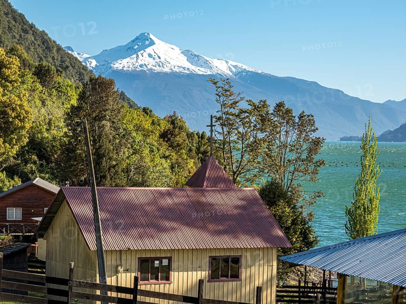 Farm and chapel at the Reloncavi fjord southeast of Puerto Montt, volcano Yates, Chile, South America