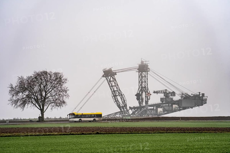 Mining excavator at the Garzweiler II open-cast lignite mine at the former, demolished village of Lützerath, on the L12 country road, in the fog, EK3 bus, North Rhine-Westphalia, Germany, Europe