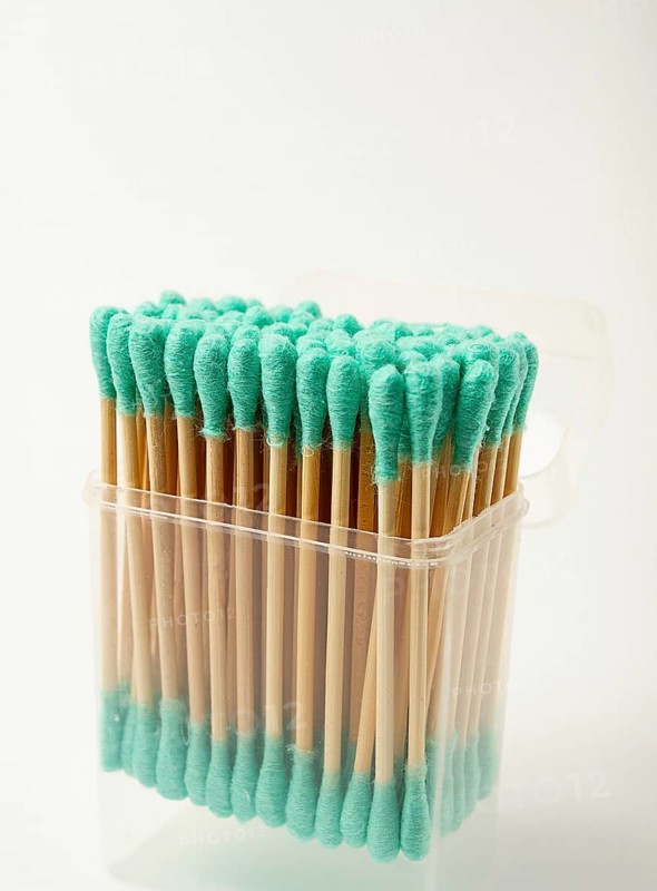 Bamboo cotton swabs, green, on a light background, in a package
