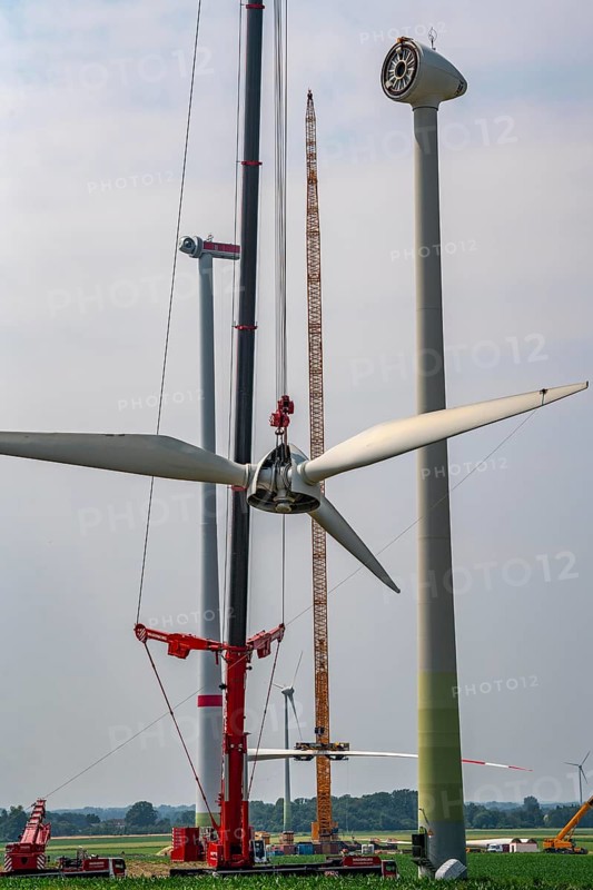 Dismantling of a wind power plant in a wind farm near Issum, 9 older wind turbines from the manufacturer Enercon (model series E-58), front, blades being dismantled, were in operation for over two decades, will be replaced by a total of four Enercon E-160 turbines, rear, assembly of the first blade, with a total output of 22 megawatts, Lower Rhine, North Rhine-Westphalia, Germany, Europe