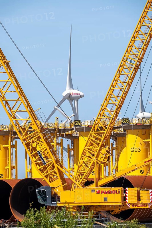 Transhipment centre for offshore wind turbines, which are transported here by the manufacturer and then shipped by special ships to the construction sites of the wind farms in the North Sea, here, yellow, so-called Transition Pieces Jackets, which are mounted on the monopile foundations driven into the seabed, on which the actual wind turbine is then mounted, in the port area of Vlissingen-Oost, Netherlands