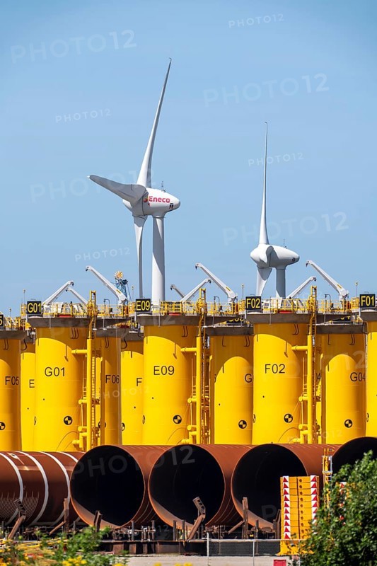 Transhipment centre for offshore wind turbines, which are transported here by the manufacturer and then shipped by special ships to the construction sites of the wind farms in the North Sea, here, yellow, so-called Transition Pieces Jackets, which are mounted on the monopile foundations driven into the seabed, on which the actual wind turbine is then mounted, in the port area of Vlissingen-Oost, Netherlands