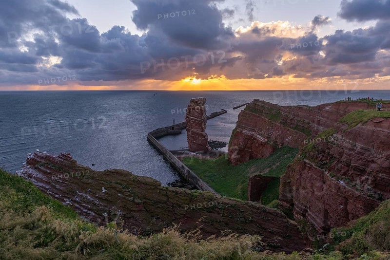 Red sandstone cliff with Lange Anna on the offshore island of Heligoland, pier as protection against erosion, evening light, cloudy sky, North Sea, Pinneberg district, Schleswig-Holstein, Germany, Europe