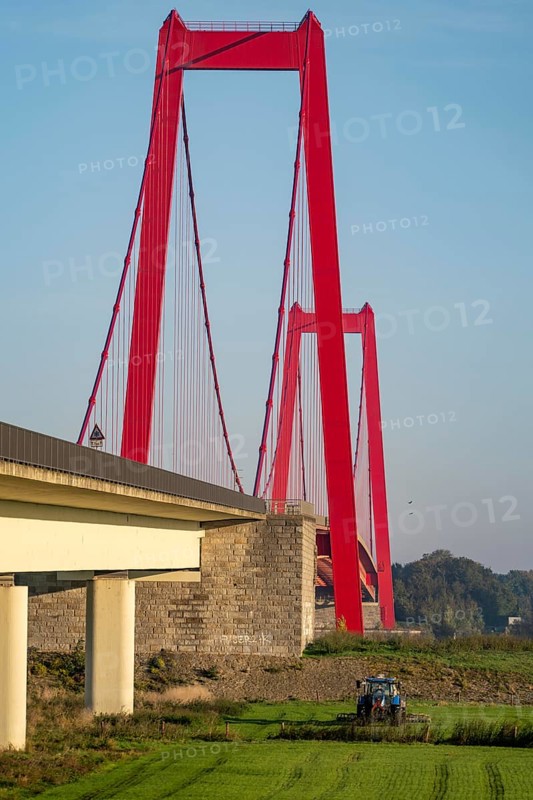 The Rhine bridge Emmerich, federal road B220, longest suspension bridge in Germany, is currently being renovated, bridge damage, farmer with tractor brings liquid manure onto the field, Lower Rhine, North Rhine-Westphalia, Germany, Europe