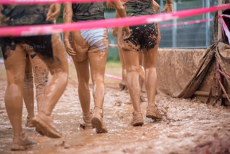 Group of participants in a muddy outdoor obstacle course