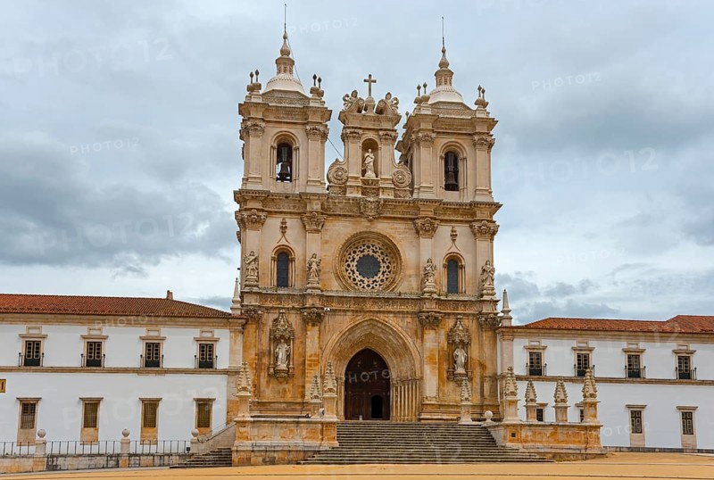 Majestic Gothic monastery façade with ornate towers against a cloudy sky, Mosteiro de Alcobaça, Monastery, Alcobaca, Oeste, Centro, Portugal, Europe