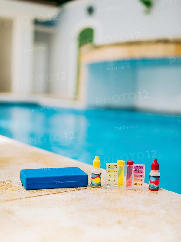 Chlorine and ph tester for swimming pools. Water test kit on the edge of the swimming pool. Chlorine test kit for swimming pools