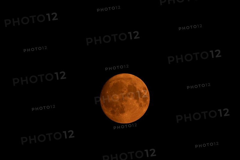 Full super moon red orange in colour in the night sky, Suffolk, England, United Kingdom, Europe