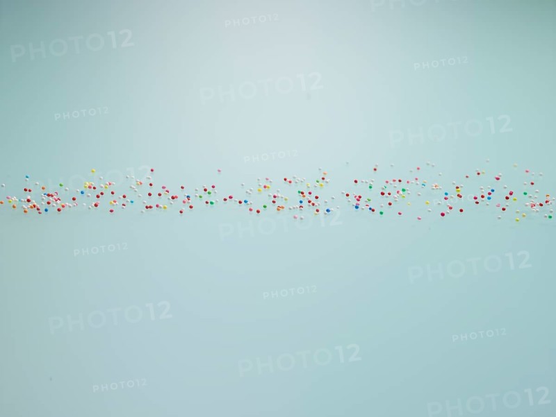 Colourful nonpareils, sugar pearls, sprinkle decorations in bright colours, mini sugar balls for decorating ice cream, cakes and muffins, studio shot