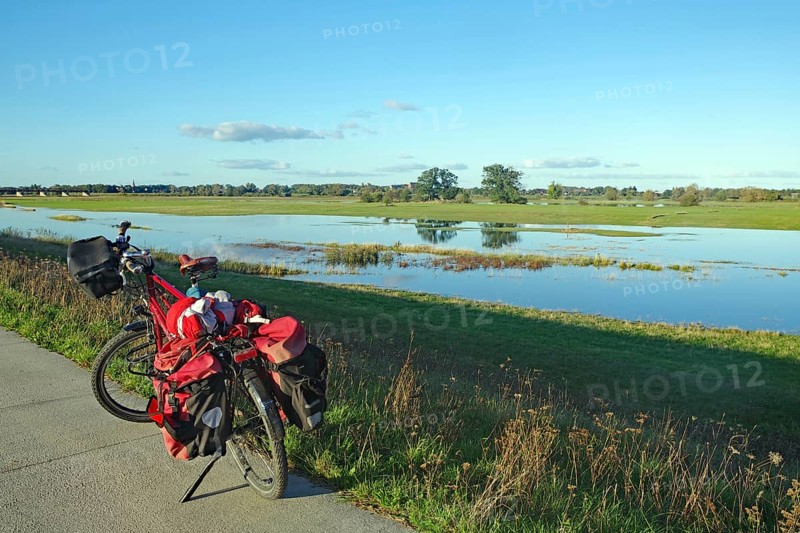 A bicycle stands at the edge of a dyke path next to a flooded Elbe meadow in a wide meadow landscape, Elbe, Langendorf, Wendland, Lower Saxony, Germany, Europe