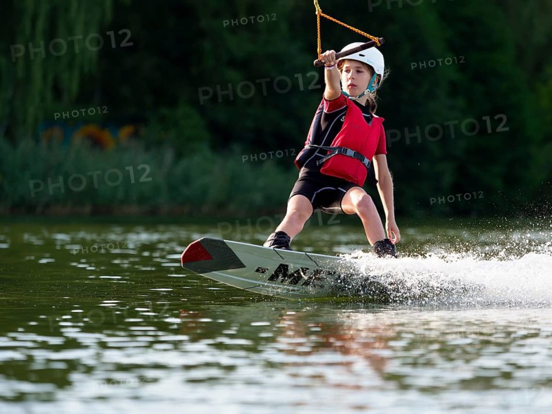 Boy or girl with wakeboard in the lake, water sports, water skiing in the wake park