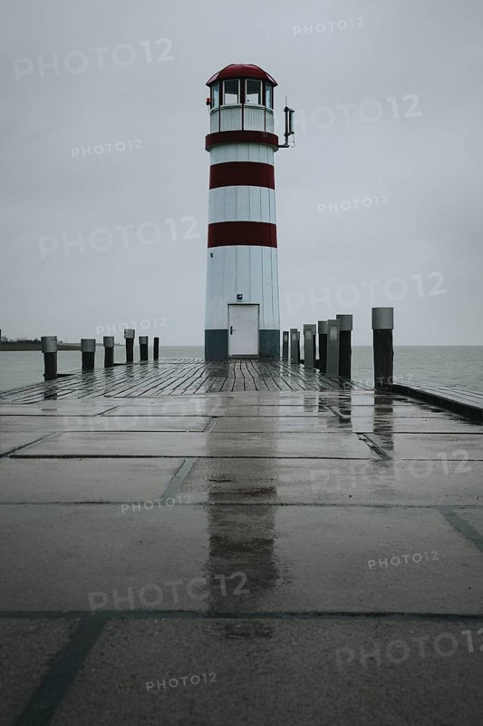 Lighthouse on a wooden jetty, surrounded by a rainy sky, Podersdorf, Burgenland, Austria, Europe