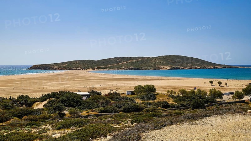 A quiet beach with sand dunes and a lush green island in the background under a bright blue sky, Prasonisi, island in the south of Rhodes, Rhodes, Dodecanese, Greek Islands, Greece, Europe