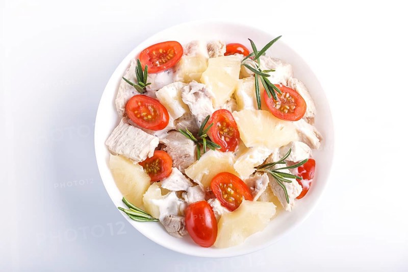 Chicken fillet salad with rosemary, pineapple and cherry tomatoes isolated on white background. close up, top view