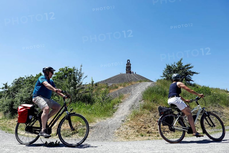 E-bikers cycle to the Rheinelbe spoil tip in Gelsenkirchen. The Himmelstreppe sculpture stands on the highest point of the spoil tip, Gelsenkirchen, 13/06/2021