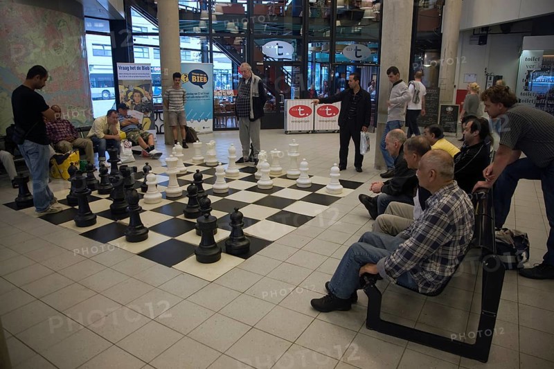 Men playing chess with a giant set of board and pieces in the central library, Rotterdam, Netherlands