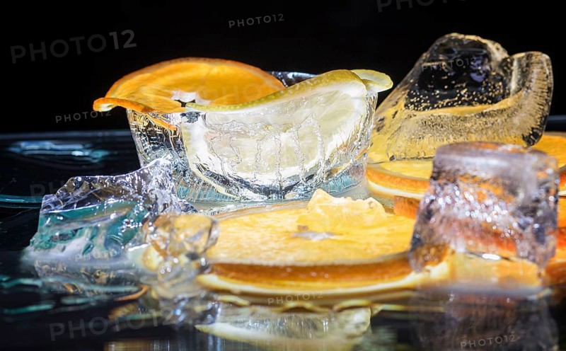 Transparent slices of fresh oranges and lemons on the glass with ice