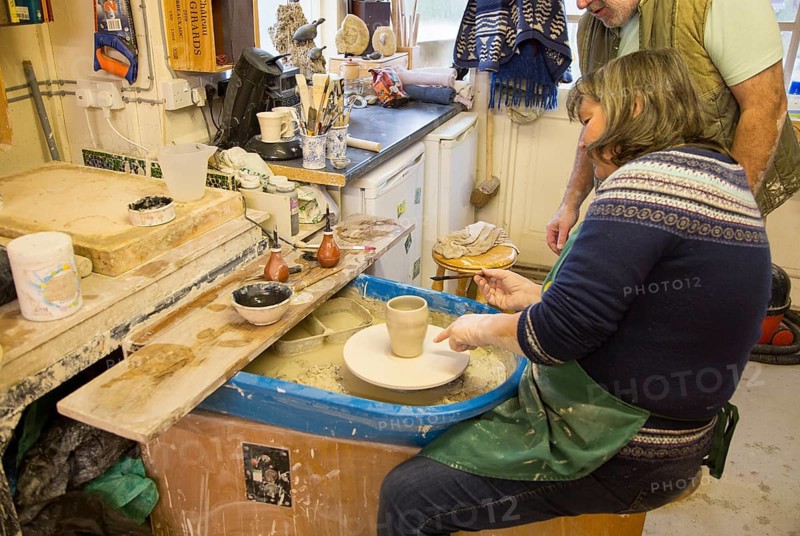Woman pottery class lesson learning making pot in potters studio UK