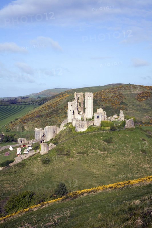 Corfe Castle is located in a natural defensive site on a hill between chalk ridges and for a thousand years has guarded the entry into the Isle of Purbeck. The ruined state of the castle date from the English Civil War when it was twice held siege in the 1640s and subsequently largely demolished