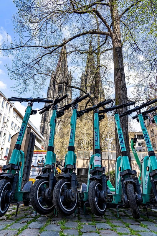 Electric scooters, e-scooters are parked in large numbers on the Burgmauer road, in front of Cologne Cathedral, legal parking area, partly signposted, Cologne, North Rhine-Westphalia, Germany, Europe