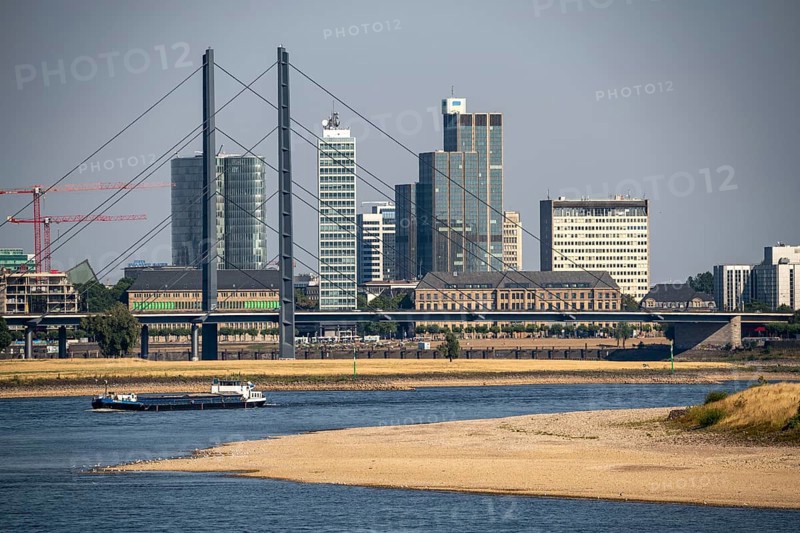 Rhine at Düsseldorf, extremely low water, Rhine level at 47 cm, falling, barge in front of the skyline with the Rheinkneibrücke bridge, sandbanks, freighters are only allowed to sail with very reduced cargo and very slowly, North Rhine-Westphalia, Germany, Europe