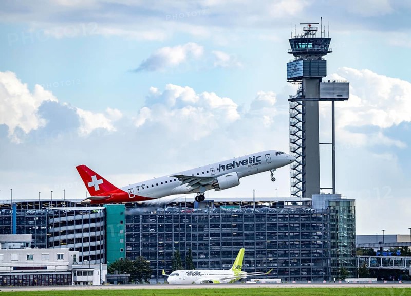 Helvetic Airways, Embraer E190-E2, HB-AZD, on take-off at Düsseldorf International Airport, air traffic control tower