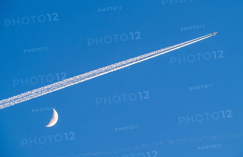 Aeroplane in the sky, vapour trail, crescent moon, waxing crescent moon, over Frankfurt am Main Germany