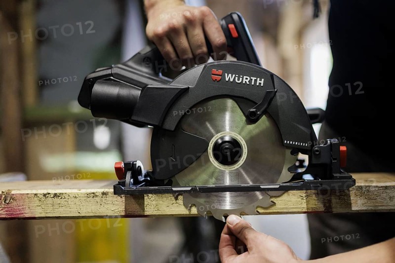 A man adjusts the cutting depth of a hand-held circular saw. Berlin, 14.08.2024