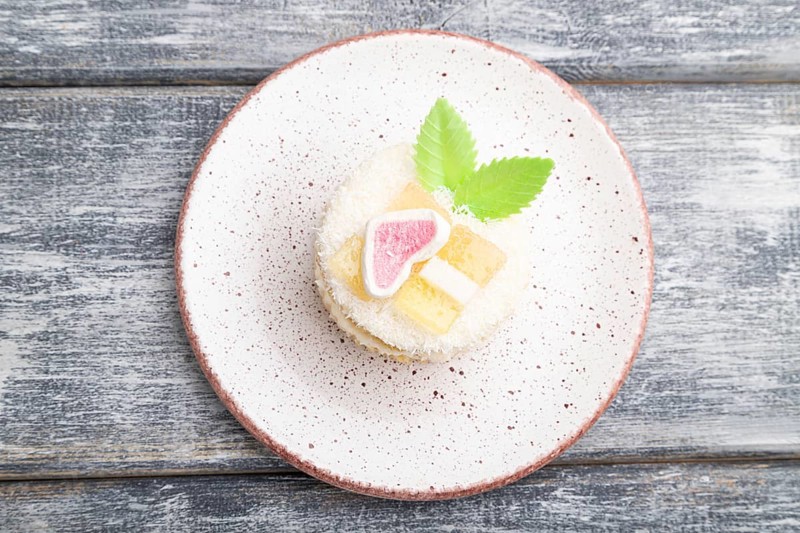 Decorated cake with milk and coconut cream on a gray wooden background. top view, flat lay, close up