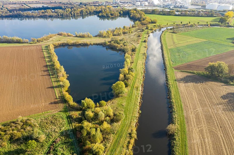 River Leine meanders through farmland and meadows, sugar factory of company Nordzucker in the back, near Nordstemmen south of Hannover, Germany, Europe