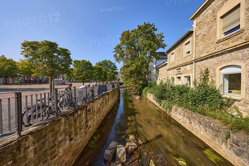 River Salze with historic buildings at the Salzhof square under a blue cloudless sky in the city centre of Bad Salzuflen, Lippe district, North Rhine-Westphalia, Germany, Europe
