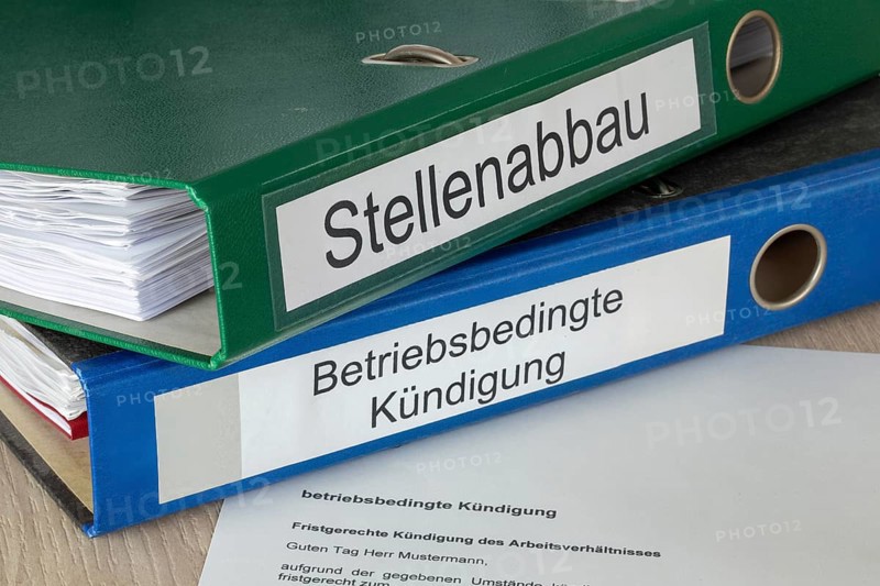 Cancellation in front of folders labelled STELLENABBAU and BETRIEBSBEDING KÜNDIGUNG (symbolic image)