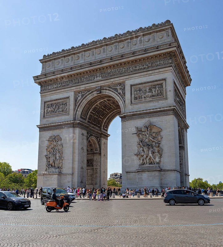 The Arc de Triomphe in Paris in sunny weather, surrounded by people and cars, Paris