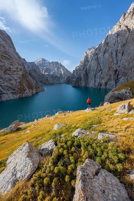 Tourist at the blue mountain lake between rocky steep mountain peaks, Kol Suu Lake, Sary Beles Mountains, Naryn Province, Kyrgyzstan, Asia