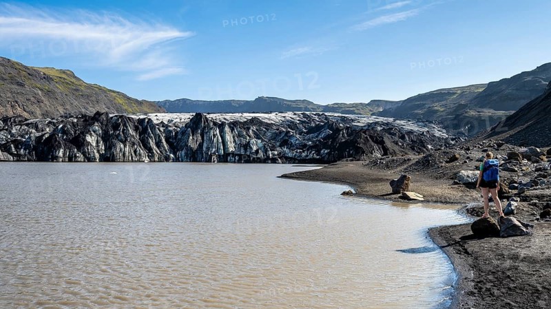 Tourist on the shore of a glacier lagoon, glacier tongue and lake, Sólheimajökull, South Iceland, Iceland, Europe