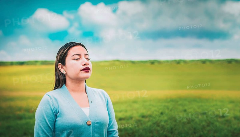 Close up of relaxed woman breathing fresh air in the field. Relaxed girl breathing fresh air in the field