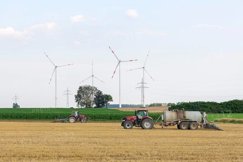 Farmers spread liquid manure on harvested grain field and plough it up, wind farm, Swabian Alb, Baden-Württemberg, Germany, Europe